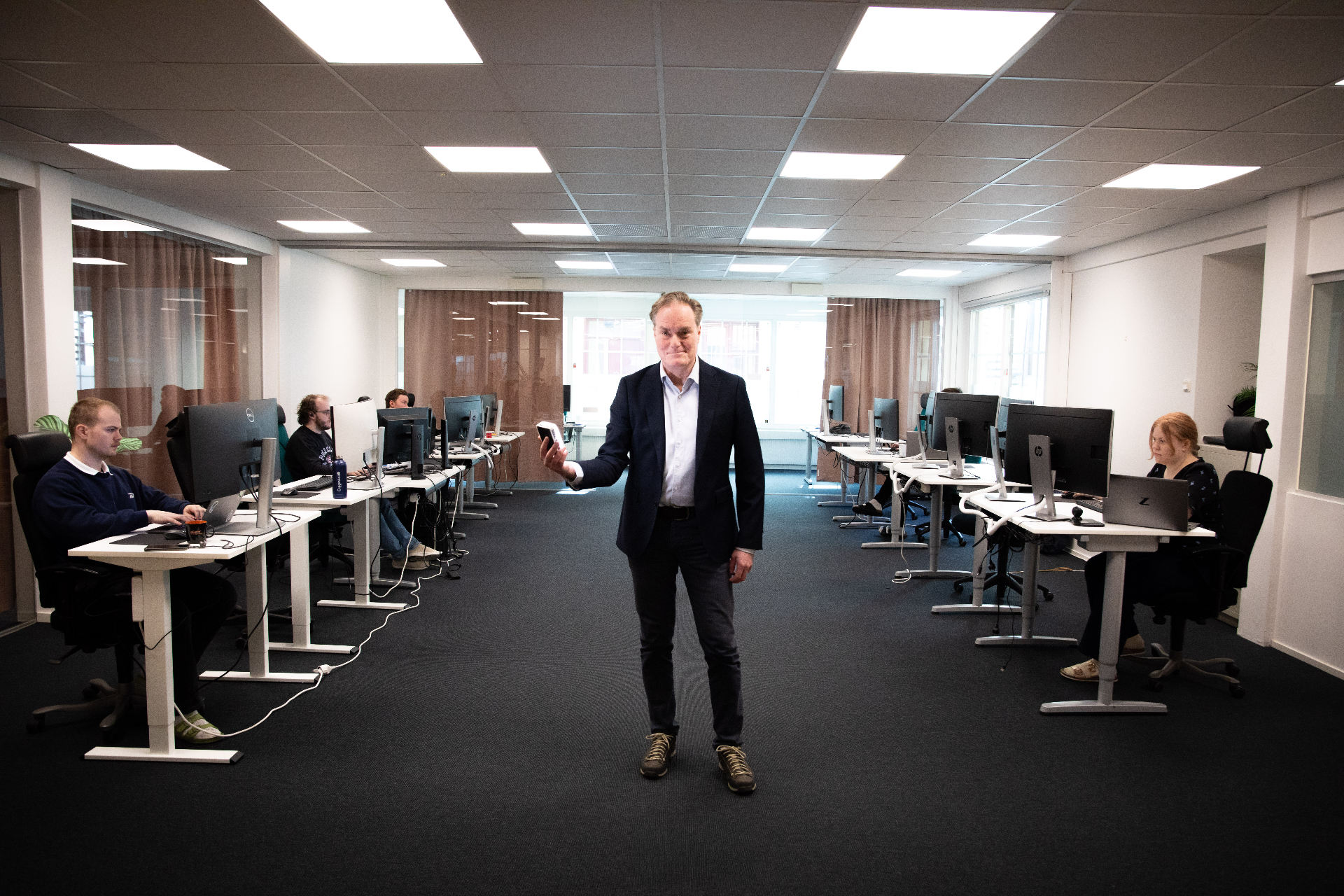 Jonas Bäckman in the Gemit Solutions office with the team working in the background