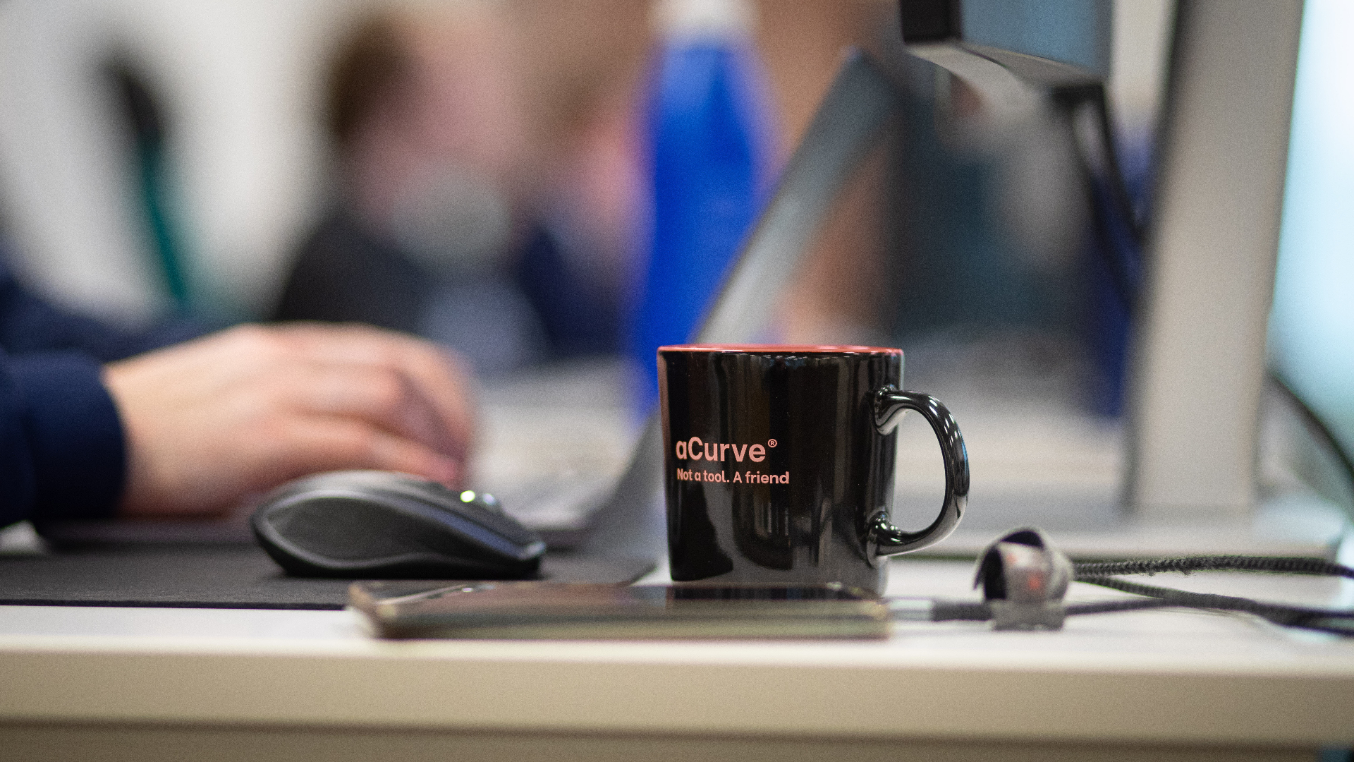aCurve-branded mug on a workstation